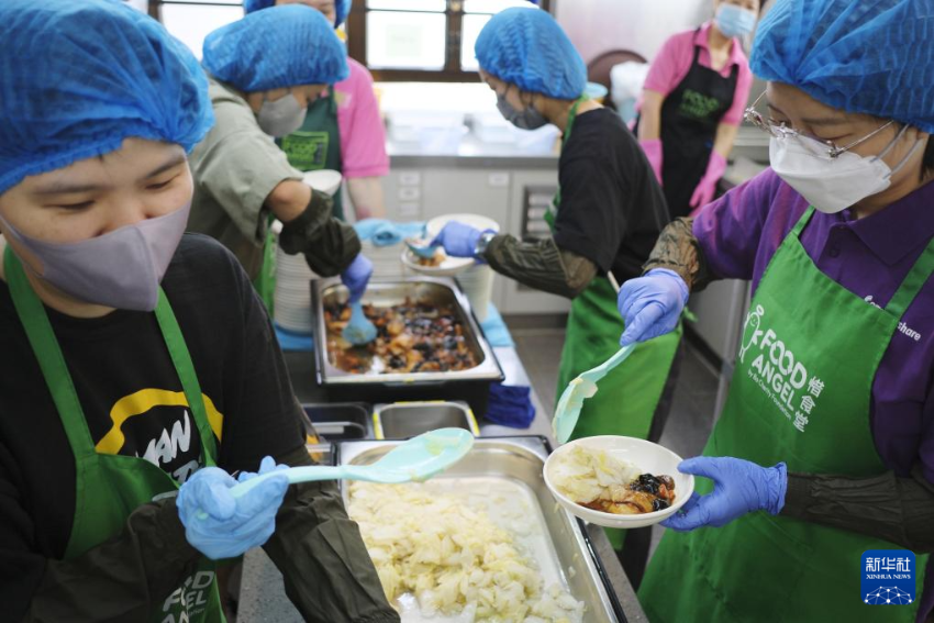 在香港深水埗的惜食堂社区中心，义工在帮助分发饭菜（5月7日摄）。