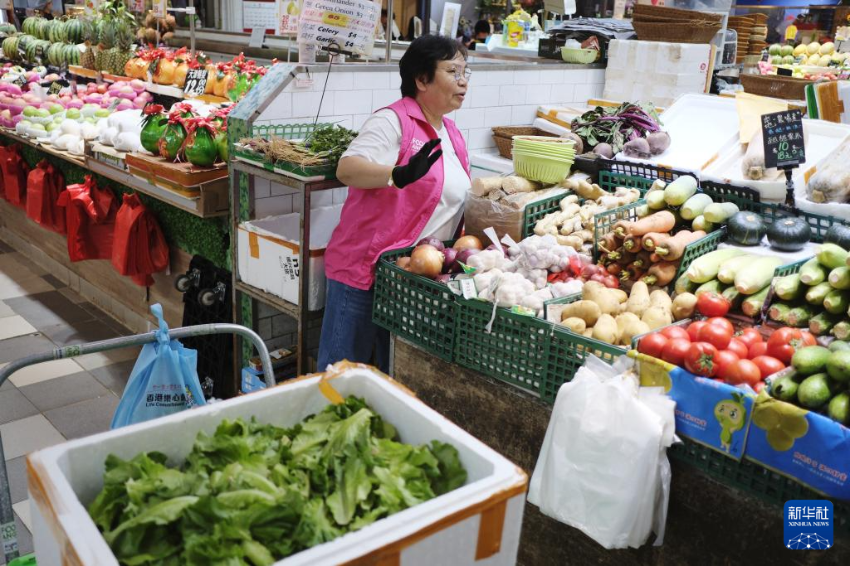 在香港南昌荟街市，“惜食堂”食物回收员阿珍收集商户当日未售出但仍可安全食用的蔬菜（5月7日摄）。