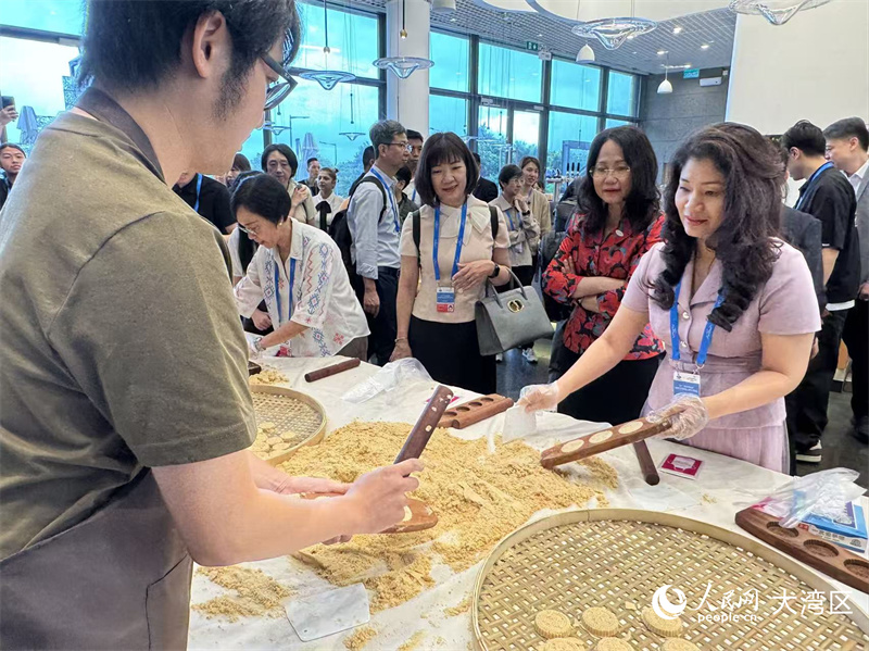 图为与会代表们饶有兴致地学做杏仁饼。