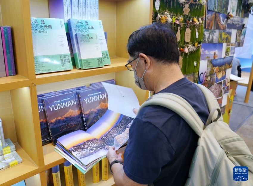 7月15日,在香港会展中心,读者在内地展区主题省云南展区观看画册。 7月15日,在香港会展中心,读者在内地展区主题省云南展区观看画册。