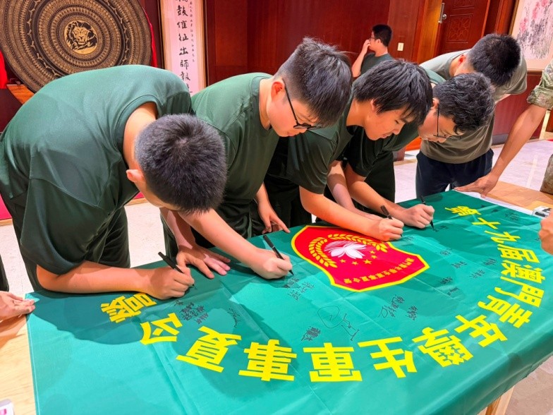 图为学员们在营旗上签名留念。