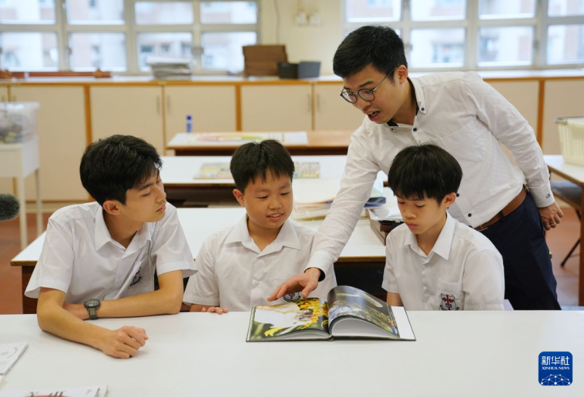 香港圣类斯中学的教师黄诚杰在辅导学生学习鹦鹉的知识（7月7日摄）。