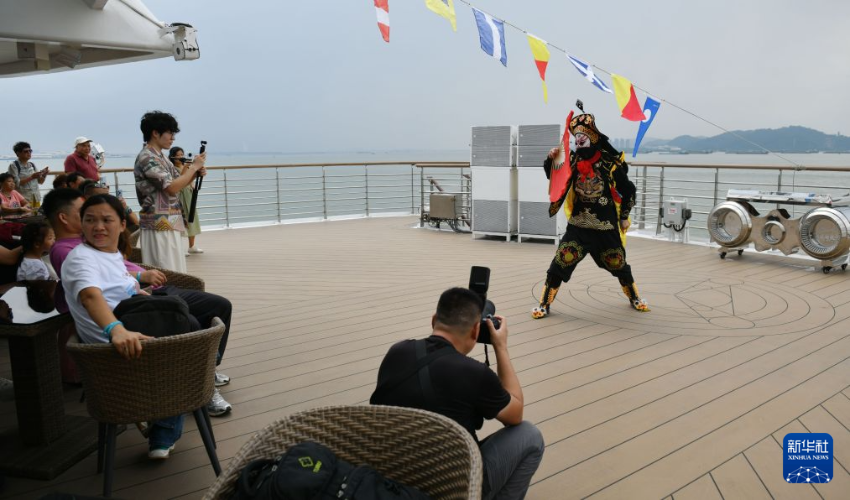 8月22日，游客在“大湾区伊敦号”游轮上观看变脸表演。