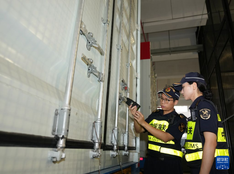 8月26日，横琴海关关员对装载首单打板货物的跨境货车施封粤澳海关“跨境一锁”。