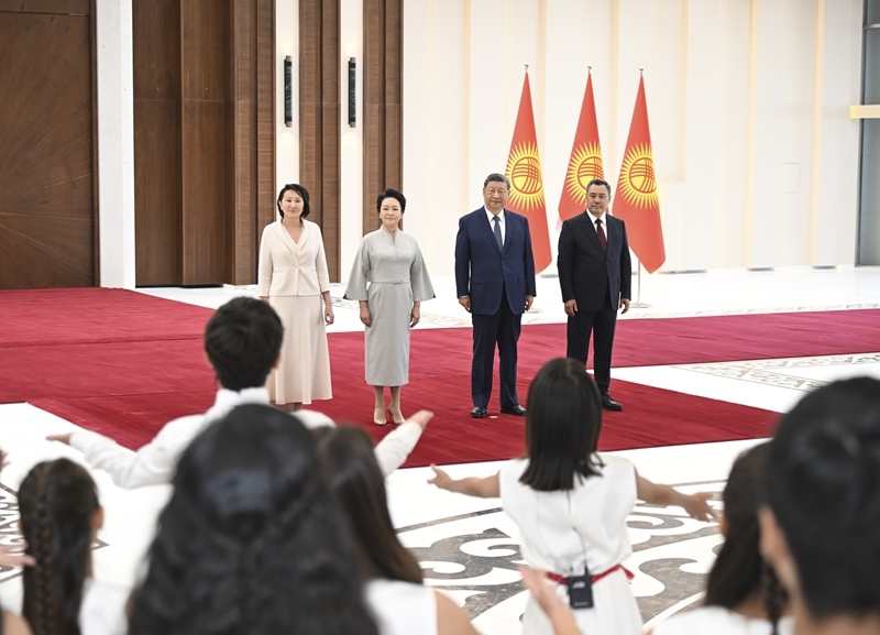 当地时间8月30日下午，国家主席习近平乘专机抵达比什凯克，应吉尔吉斯斯坦总统扎帕罗夫邀请，出席2026年上海合作组织峰会并对吉尔吉斯斯坦进行国事访问。习近平和夫人彭丽媛抵达比什凯克玛纳斯国际机场时，扎帕罗夫总统夫妇热情迎接。这是两国元首夫妇共同欣赏当地青少年演唱中国歌曲。
