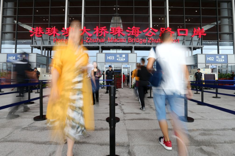港珠澳大桥正式通车当天,人们穿梭在港珠澳大桥珠海公路口岸安检口前(2018年10月24日摄)。 港珠澳大桥正式通车当天,人们穿梭在港珠澳大桥珠海公路口岸安检口前(2018年10月24日摄)。