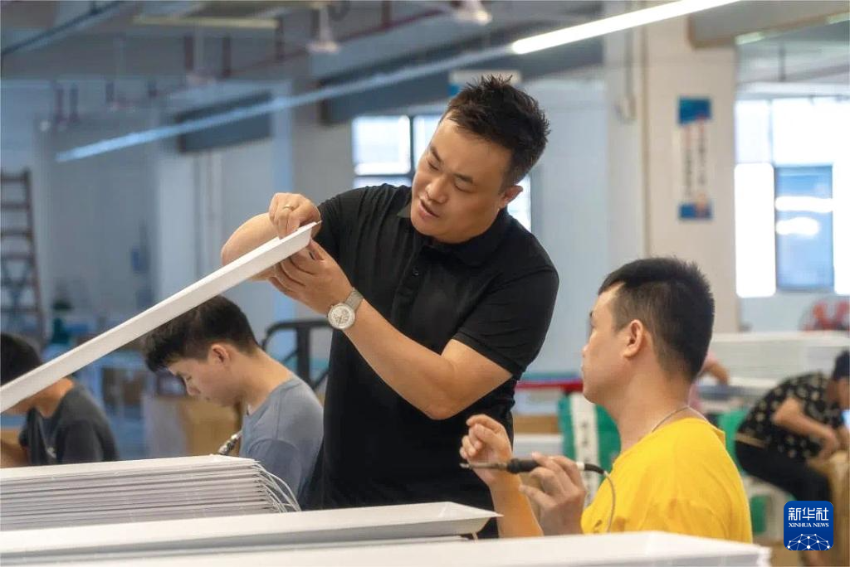工业设计师马驰（左）和同事在工作室中研究产品（资料照片）。