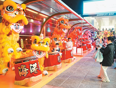 近日在香港维多利亚港畔，游客和醒狮合影。