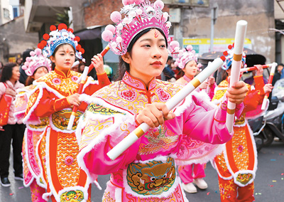 春节期间，英歌舞队员在广东省汕头市潮阳区海门镇街头巡游表演。
