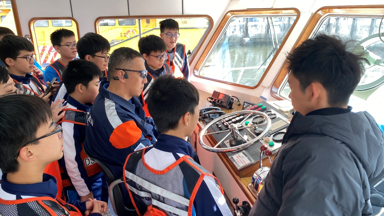 图为同学们走进驾驶舱近距离认识航海设备。
