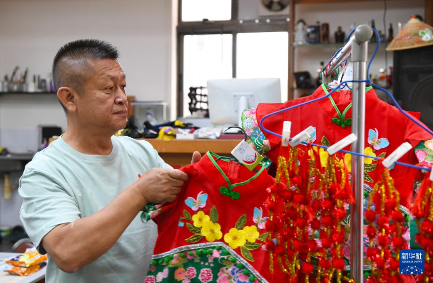4月30日，飘色师傅李智伟在整理小演员的服饰。