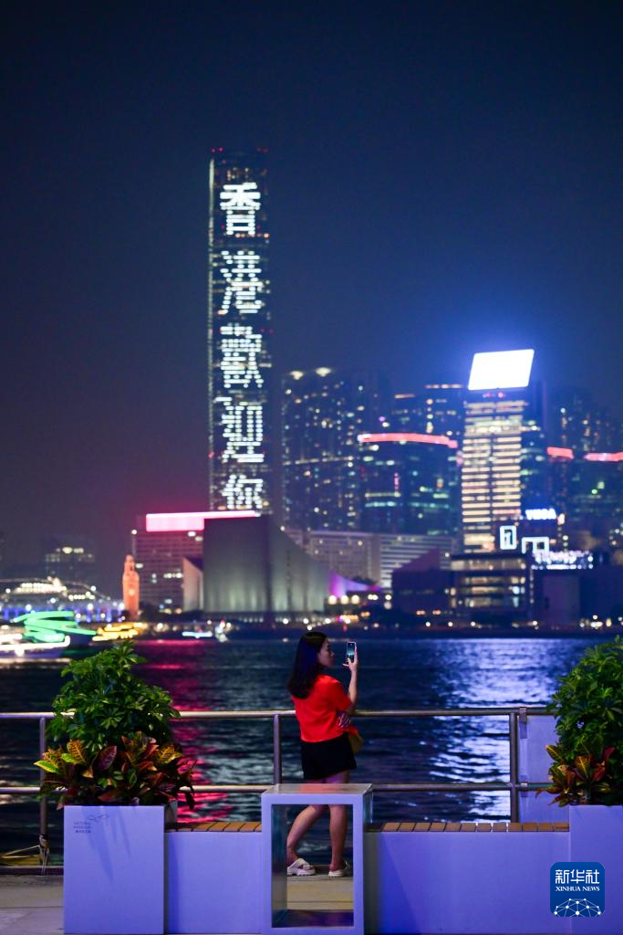 5月2日，一名女士在拍摄香港维多利亚港夜景。
