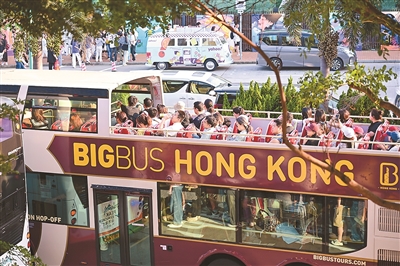 游客在香港乘坐观光巴士游览。