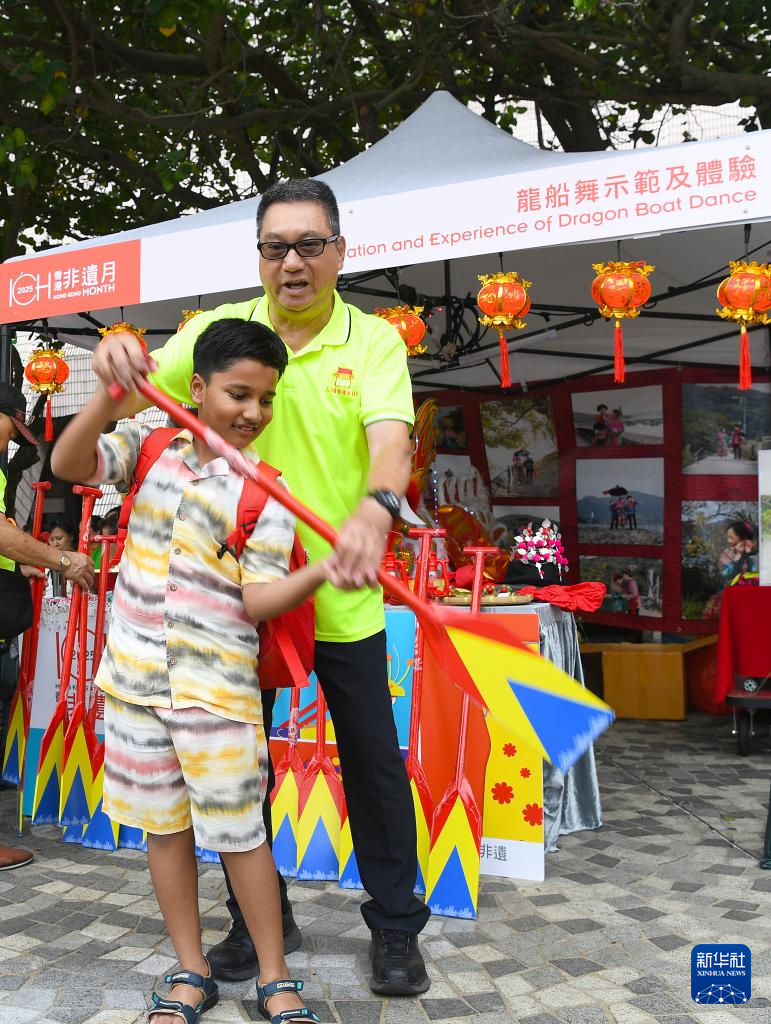 5月31日，一名男孩在香港文化中心露天广场举行的“非遗嘉年华”上体验龙船舞。