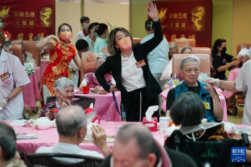 5月24日，在香港松悦园耆和护养院，安老事务委员会委员、香港乐龄社企“软餐侠”创办人文慧妍（中，穿黑色外套）带领职员扮演成“茶楼”经理、厨师和接待员，为老人家提供沉浸式茶楼就餐体验。