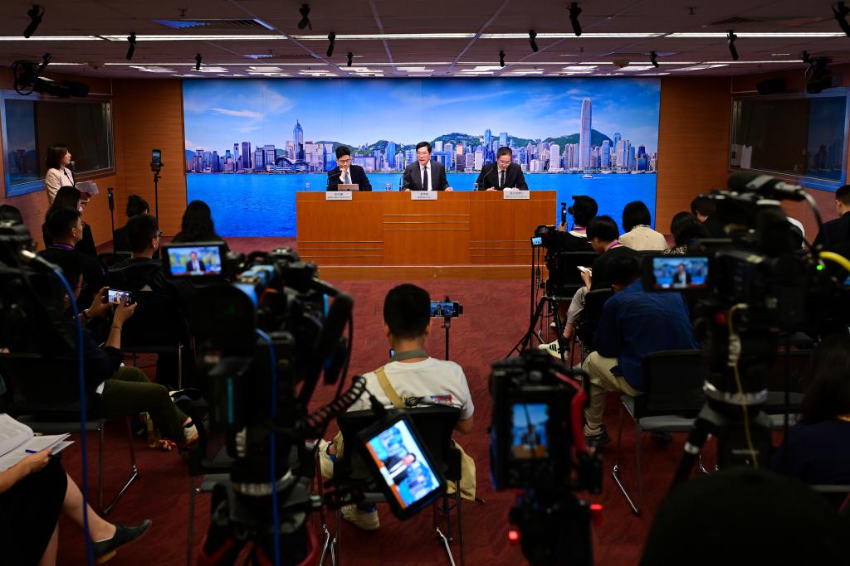 6月23日，香港特区政府署理财政司司长黄伟纶（中）等人士会见传媒。