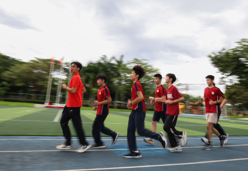 ↑图为广东现代五项运动协会教练员滕泽华（左一）带领广州市中黄港澳子弟学校学生进行慢跑训练（6月19日摄）。