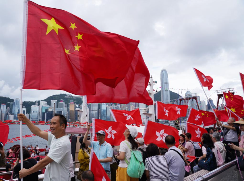 7月1日，在香港尖沙咀海滨长廊，市民手持国旗与特区区旗，欢庆香港回归祖国28周年。