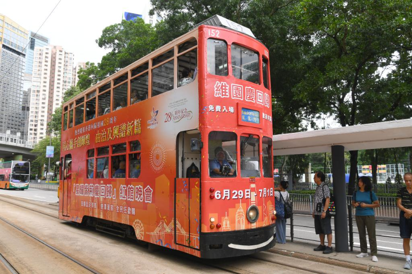7月1日，一辆涂装庆祝香港回归祖国28周年海报的电车从香港街头驶过。