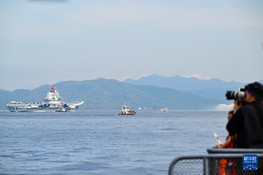 7月3日，人们在岸上拍摄海军山东舰抵达香港。