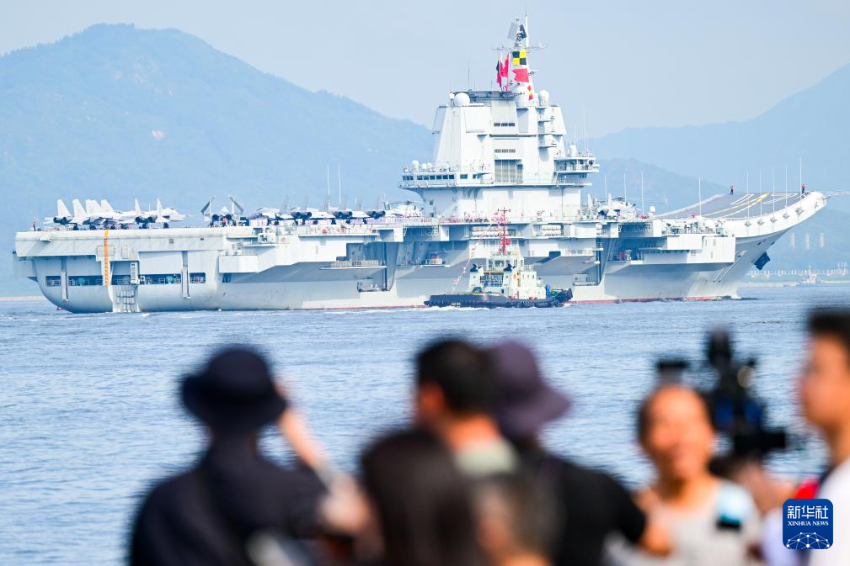 7月3日，人们在岸上拍摄海军山东舰抵达香港。
