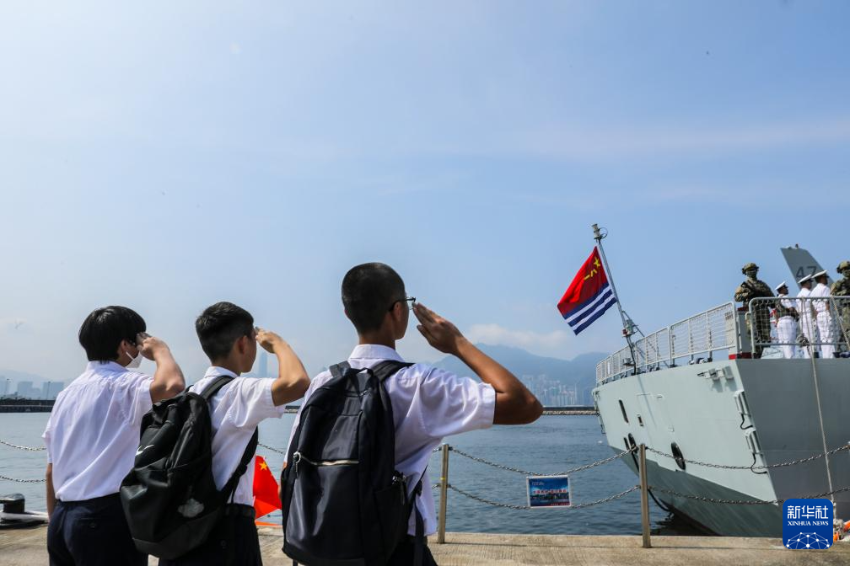7月7日，湛江舰即将驶离昂船洲军营码头，三名香港福建中学的学生向悬挂在舰尾的海军军旗敬礼。