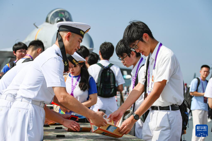 7月4日，锚泊在维多利亚港的山东舰对香港青少年学生开放。这是学生们在集章点打卡留念。