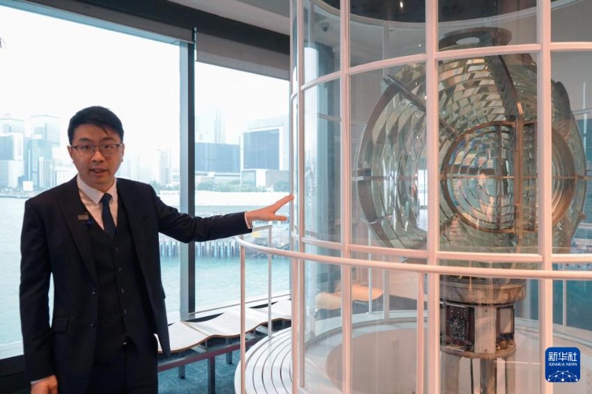 香港青年王玮乐在香港海事博物馆的灯塔信号灯模型旁向记者讲解灯塔结构（2025年4月26日摄）。