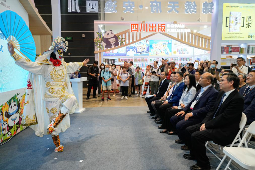 7月16日，参观者在书展上观看川剧变脸表演。