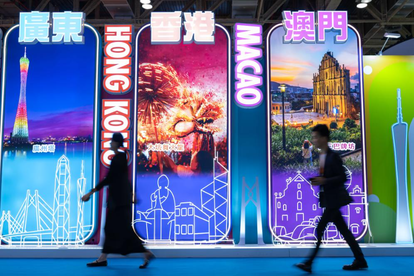 4月25日，参观者从第十三届澳门国际旅游（产业）博览会大湾区展板前经过。