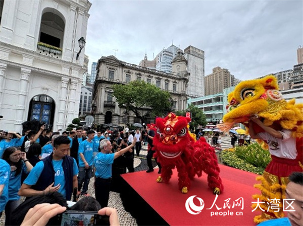 图为岑浩辉在议事亭前地与舞狮队互动。