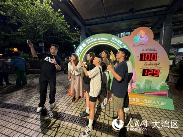 图为澳门居民与全运会倒计时牌合影留念。