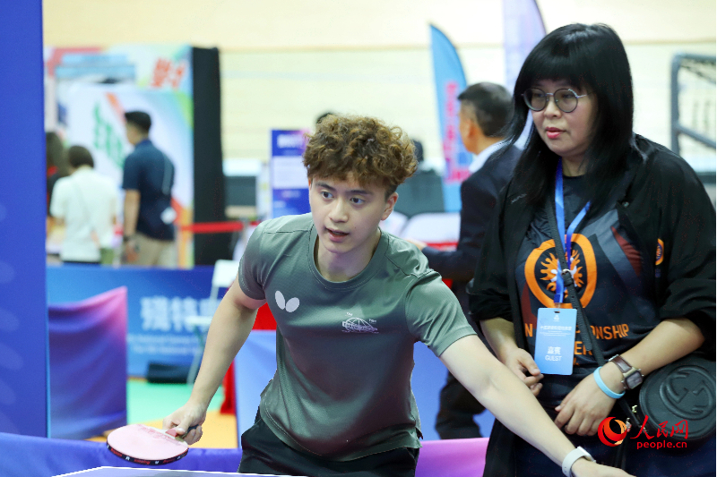 教练正在指导市民打乒乓球。 教练正在指导市民打乒乓球。