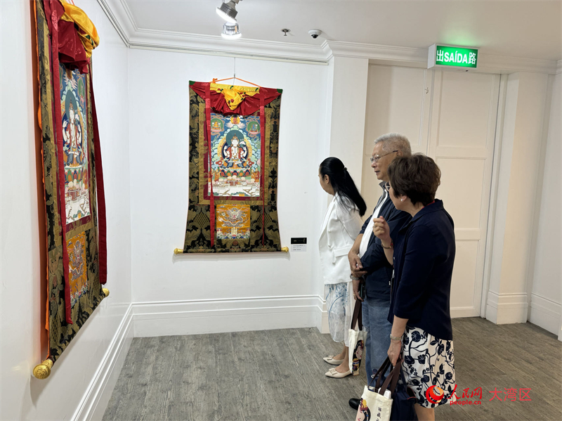 图为观众被精美的唐卡深深吸引。