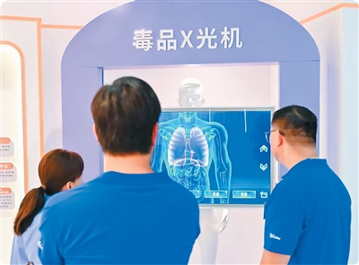 交流团成员在体验模拟毒品X光机操作。