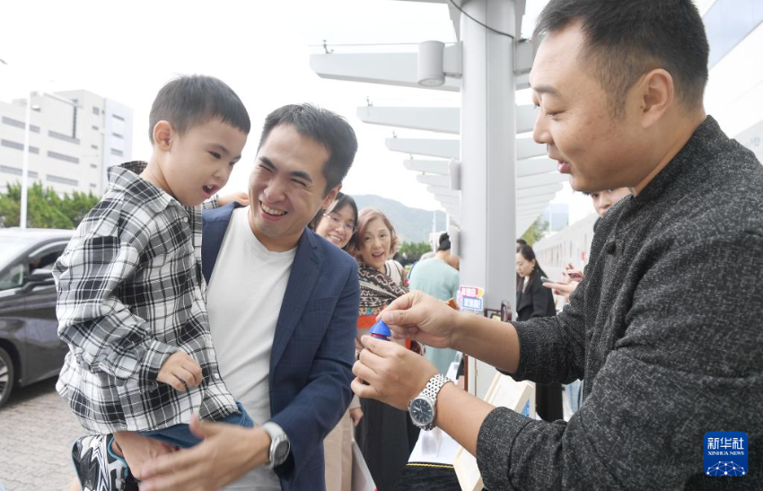 10月22日,河北民间艺术家(右)在非遗展区为小朋友表演魔术。 10月22日,河北民间艺术家(右)在非遗展区为小朋友表演魔术。