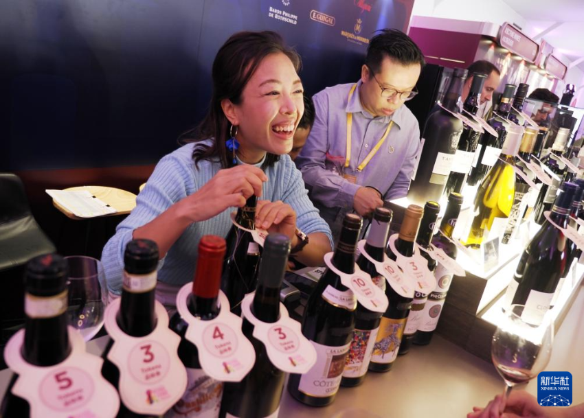 10月23日,在香港中环海滨,参展商在推介红酒。 10月23日,在香港中环海滨,参展商在推介红酒。