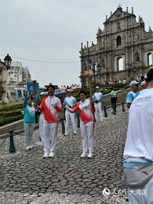 图为第47棒和48棒火炬手在大三巴牌坊前交接。人民网记者 富子梅摄 图为第47棒和48棒火炬手在大三巴牌坊前交接。人民网记者 富子梅摄