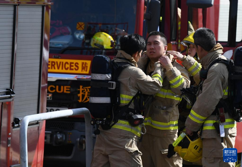 11月28日，在香港大埔区宏福苑火灾救援现场，消防员互相整理防护装备。