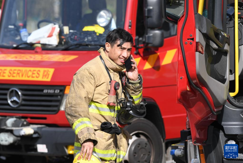 11月28日，在香港大埔区宏福苑火灾救援现场，一名消防员在打电话。