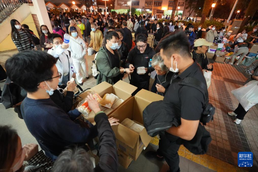 11月27日，义工在宏福苑附近向受火灾影响的市民派发物资。