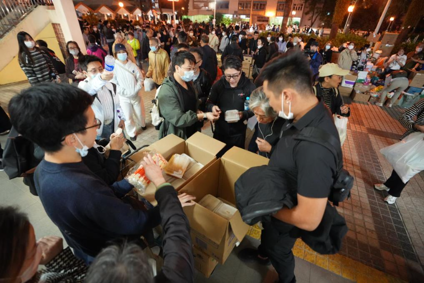 11月27日，义工在宏福苑附近向受火灾影响的市民派发物资。