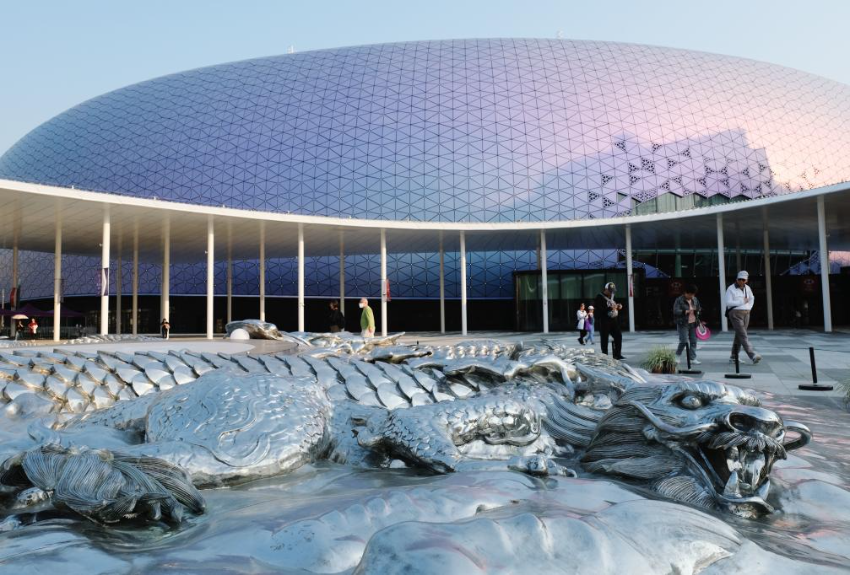 2025年3月24日，在香港启德体育园主场馆外的中央广场拍摄的圆形不锈钢浮雕《龙之九子》。