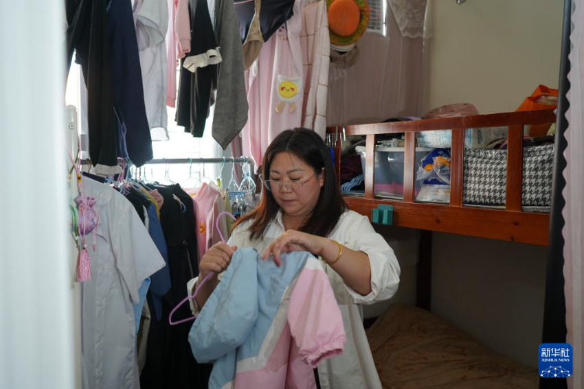 2025年11月10日，在元朗攸壆路的“简约公屋”，杜女士在家中整理衣物。