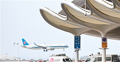 广州白云机场T3航站楼外，远处一架客机在降落。