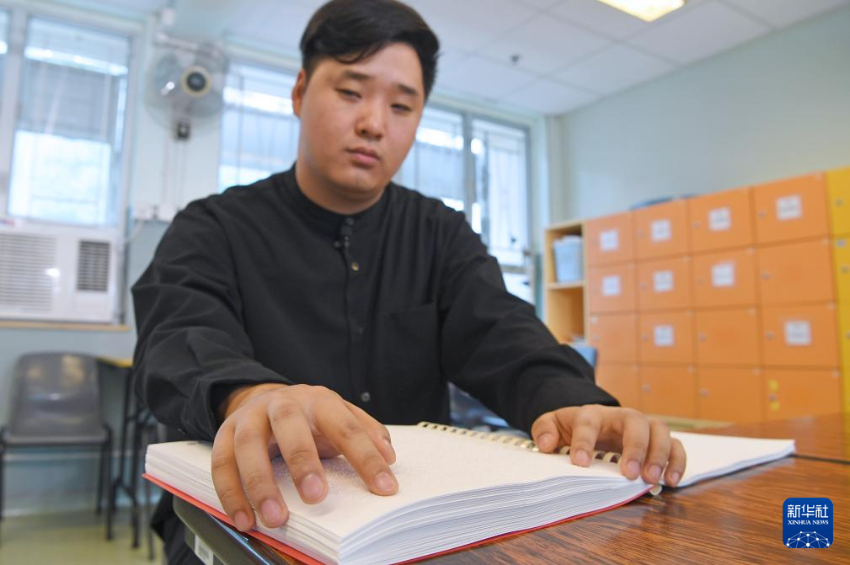 1月20日，香港地水南音说唱人杨恩华在阅读盲文图书。