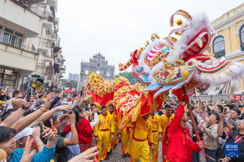 2月17日,舞龙队伍在澳门大三巴牌坊前与市民互动。 2月17日,舞龙队伍在澳门大三巴牌坊前与市民互动。