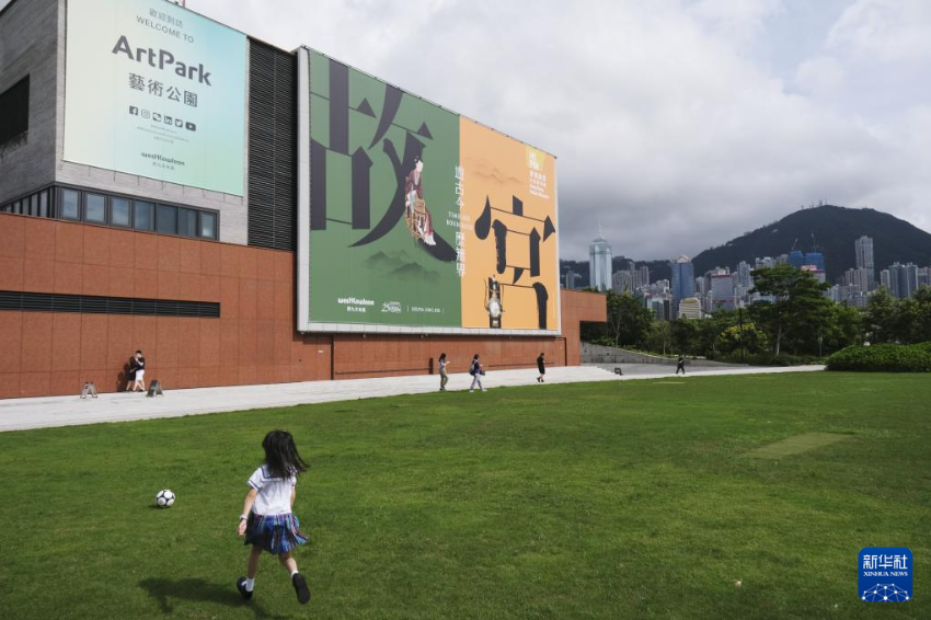 女孩在香港故宫文化博物馆旁的草坪上玩耍（2022年6月17日摄）。