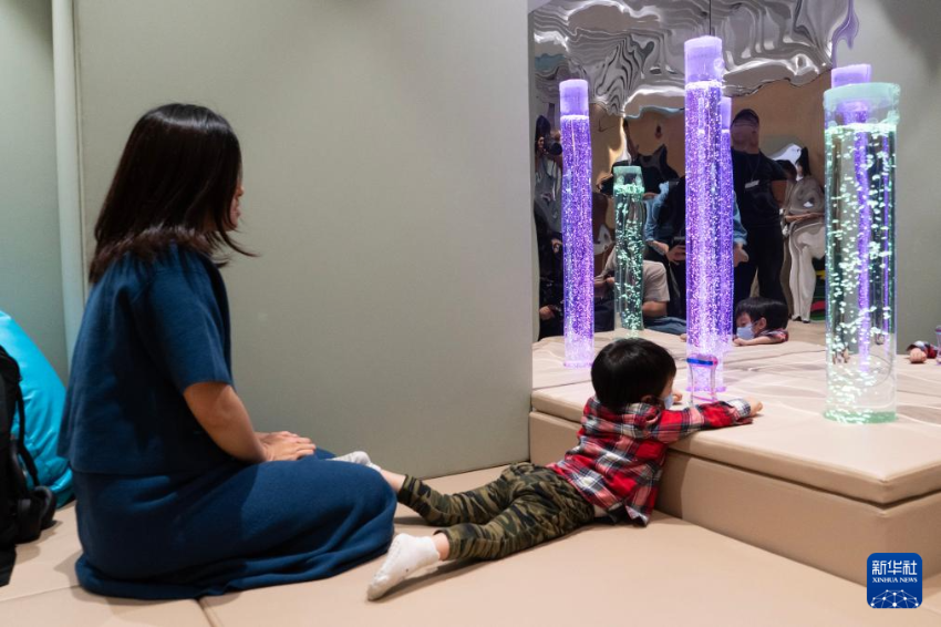 在位于香港国际机场一号客运大楼的“感知阁”内，邓女士陪伴被诊断为孤独症的儿子玩耍（3月31日摄）。 