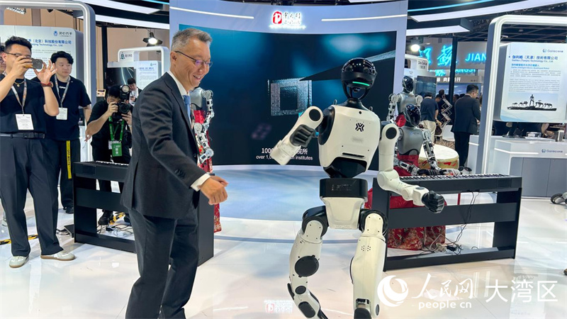 参展观众与机器人互动共舞。